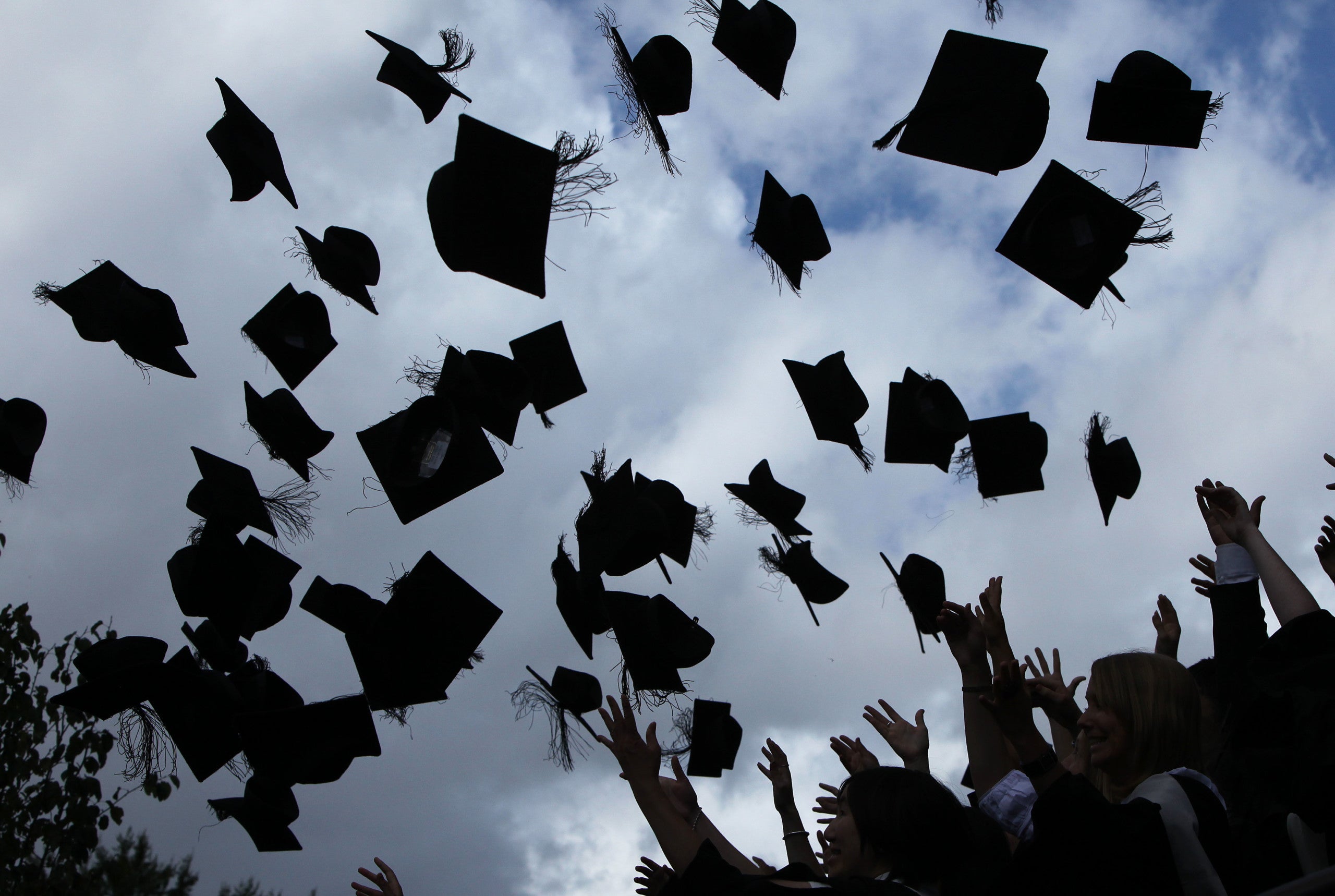 Students throw their mortarboards in the air during their graduation photograph on July 14, 2009 in Birmingham, England. (Photo by Christopher Furlong/Getty Images)