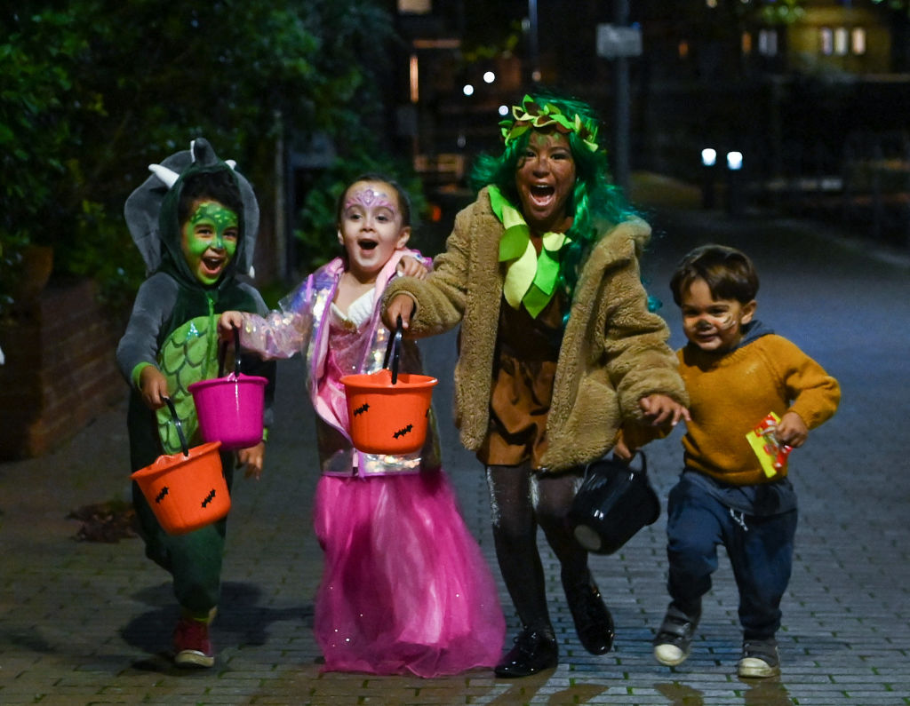 (L-R) Aaron Cana, Noa and Ezdra pose for a picture as they go trick-or-treating for Halloween in east London on October 31, 2020. (Photo by Daniel LEAL / AFP) (Photo by DANIEL LEAL/AFP via Getty Images)