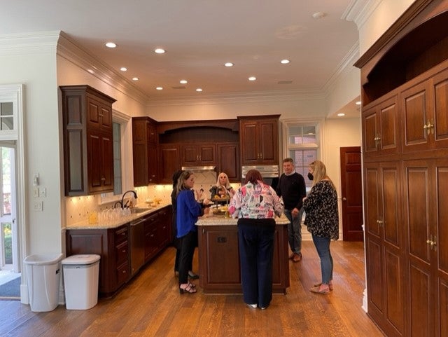 A kitchen with people around the island