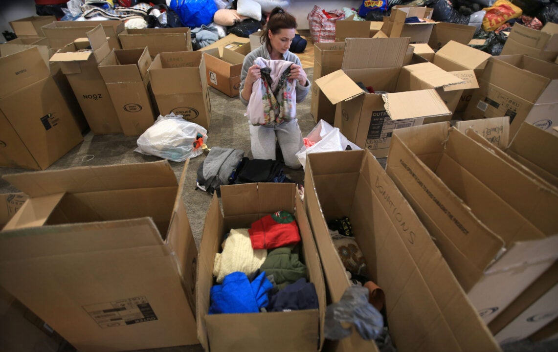 A volunteer sorts clothing bound for Ukraine at the East of England Showground on March 10, 2022 in Peterborough, England. (Photo by Martin Pope/Getty Images)