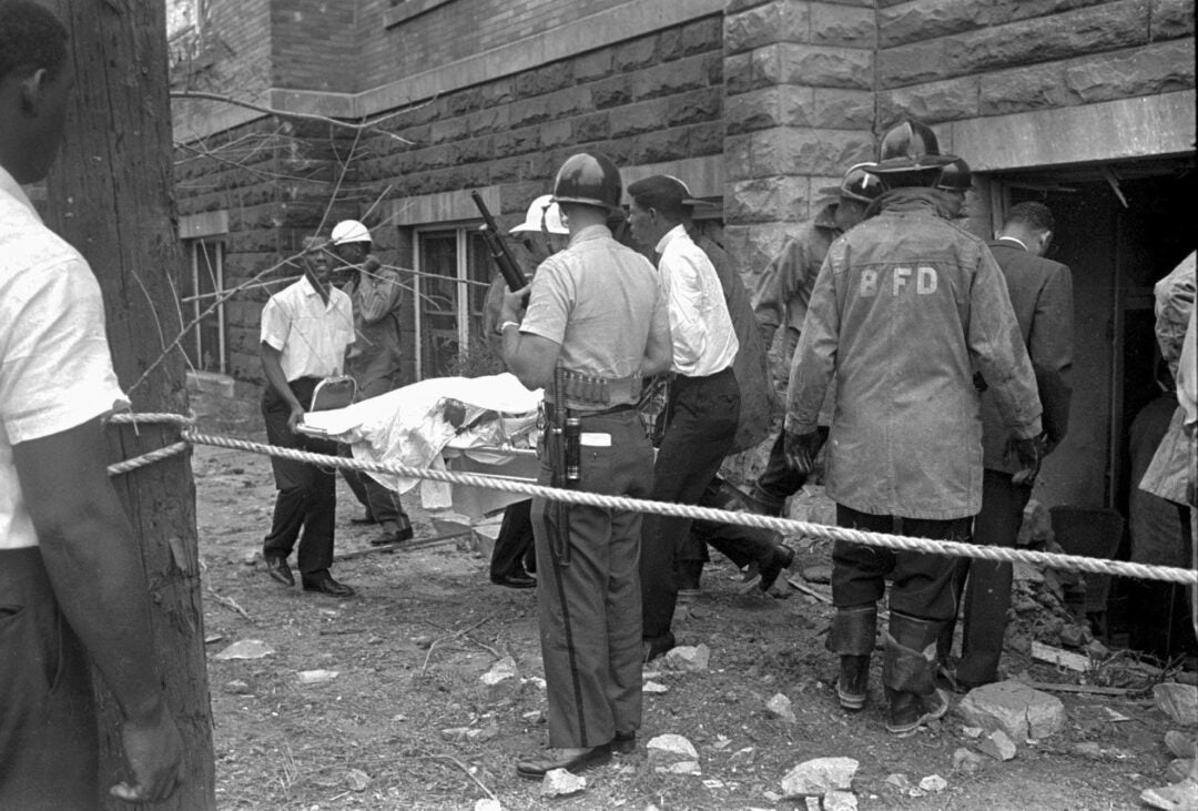 ambulance attendants remove a covered body from the 16th Street Baptist Church in Birmingham, Ala., Sept. 15, 1963, after a deadly explosion detonated by members of the Ku Klux Klan during services. Alabama on Friday, Sept. 15, 2023, will mark the 60th anniversary of the bombing that killed four girls. Lisa McNair, the sister of one of the victims, said as the anniversary is remembered, she hoped people will think about what they can do to combat hate. (AP Photo, File)