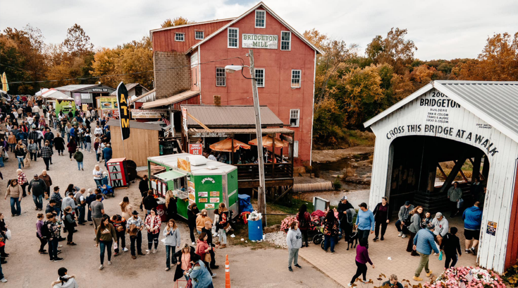 Covered bridge festival photo of a crowded street and bridge with an old building in the background