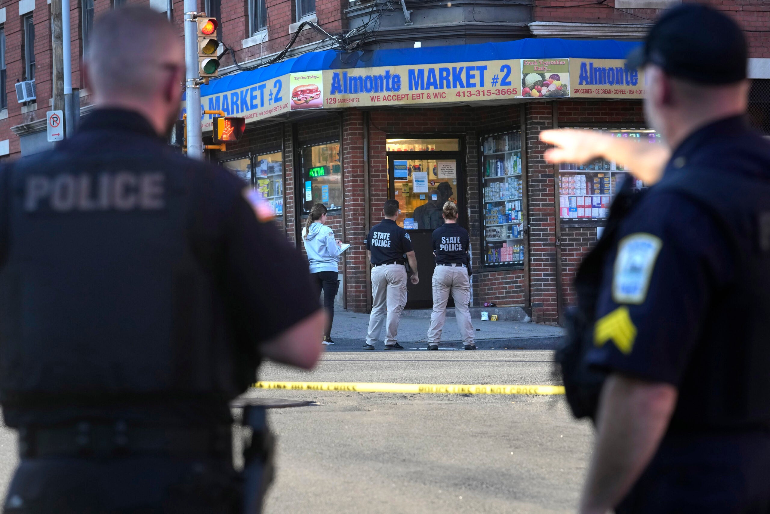 Law enforcement officials investigate the scene where multiple were shot, Wednesday, Oct. 4, 2023, in Holyoke, Mass. State police say at least three people, including a person riding a bus, were shot Wednesday in Holyoke following a fight on a downtown street.