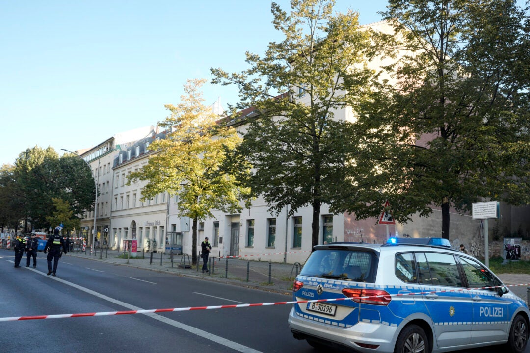 German police officers stand guard in front of the building complex, center, of the Kahal Adass Jisroel community, which houses a synagogue, a kindergarten and a community center, in the center of Berlin, Germany, Wednesday, Oct. 18, 2023. The Kahal Adass Jisroel community said its synagogue in the city's Mitte neighborhood was firebombed with two Molotov cocktails. (AP Photo/Markus Schreiber)