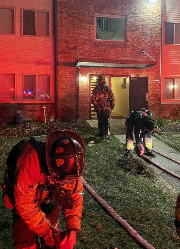 Noblesville firefighters stand outside an apartment building where two small children and an adult were rescued from an apartment fire on Dec. 13, 2023. (Provided Photo/NFD)