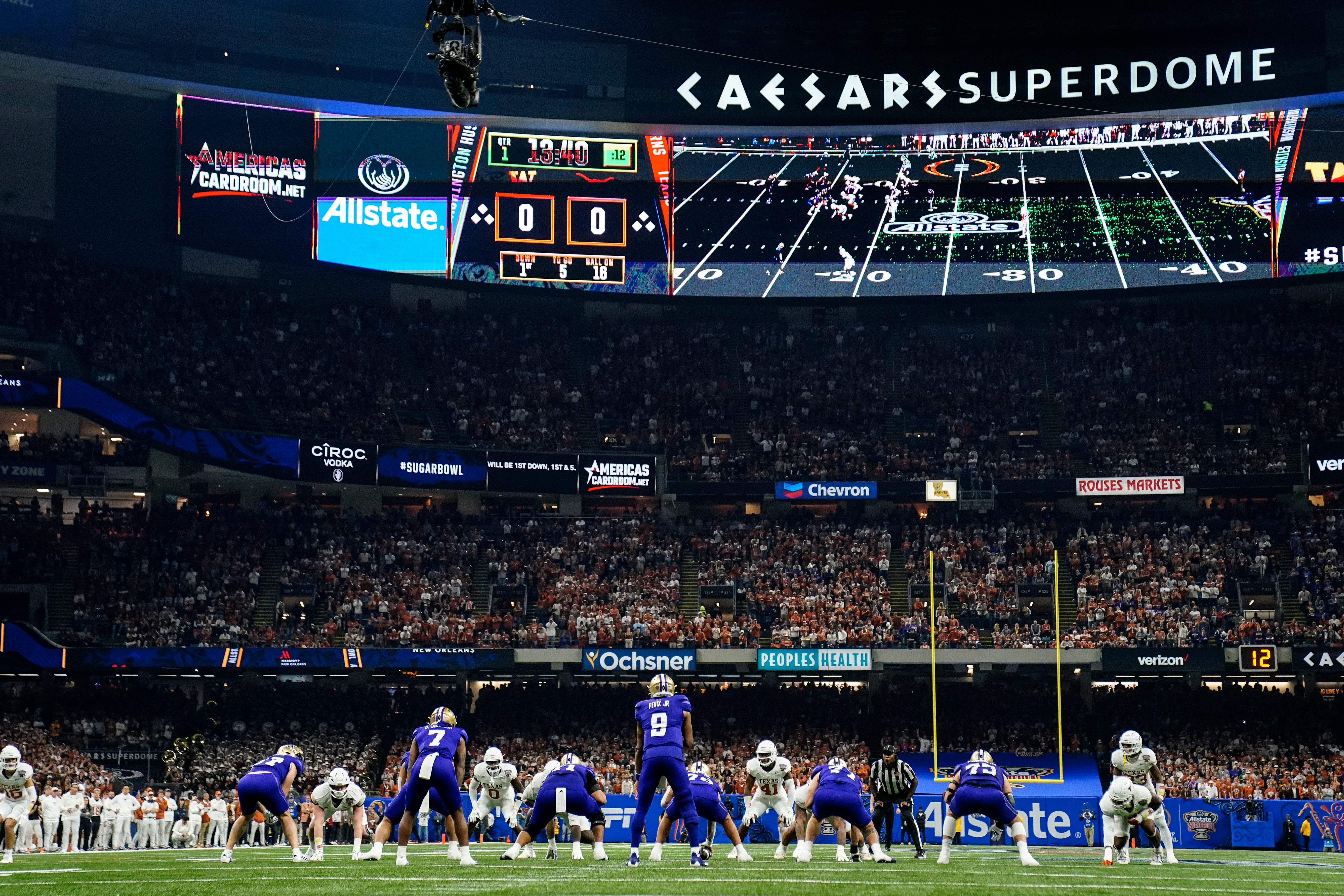 Washington playes Texas during the first half of the Sugar Bowl CFP NCAA semifinal college football game, Monday, Jan. 1, 2024, in New Orleans. ESPN has apologized for a video clip of a woman baring her breast that was shown during the broadcast of Monday's Sugar Bowl in New Orleans. (AP Photo/Jacob Kupferman)