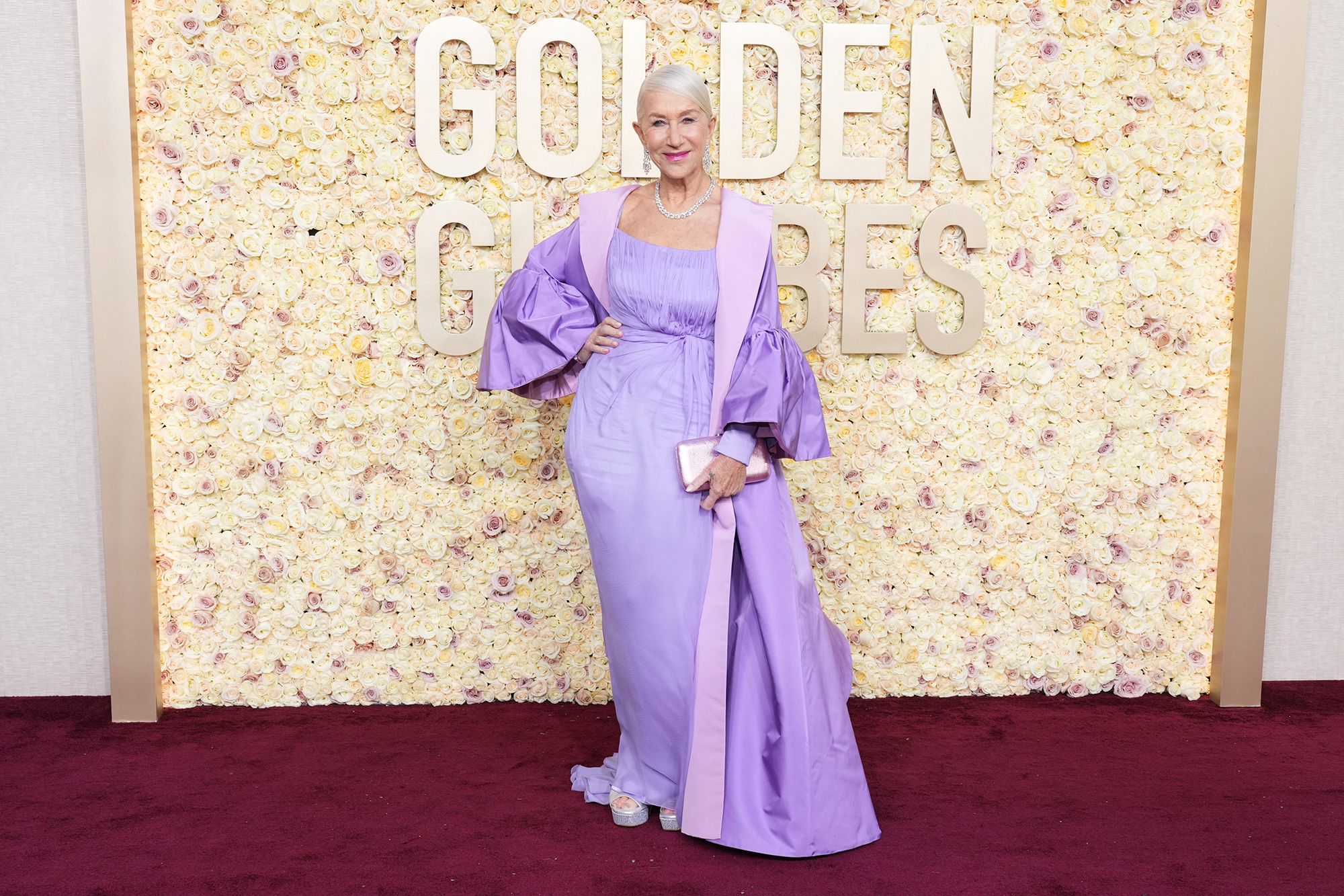 Dame Helen Mirren looked regal in a lavender Dolce & Gabbana dress and oversized puff-sleeved opera coat, silver platforms by Sole Bliss and Harry Winston jewelry. (Photo byJordan Strauss/Invision/AP)