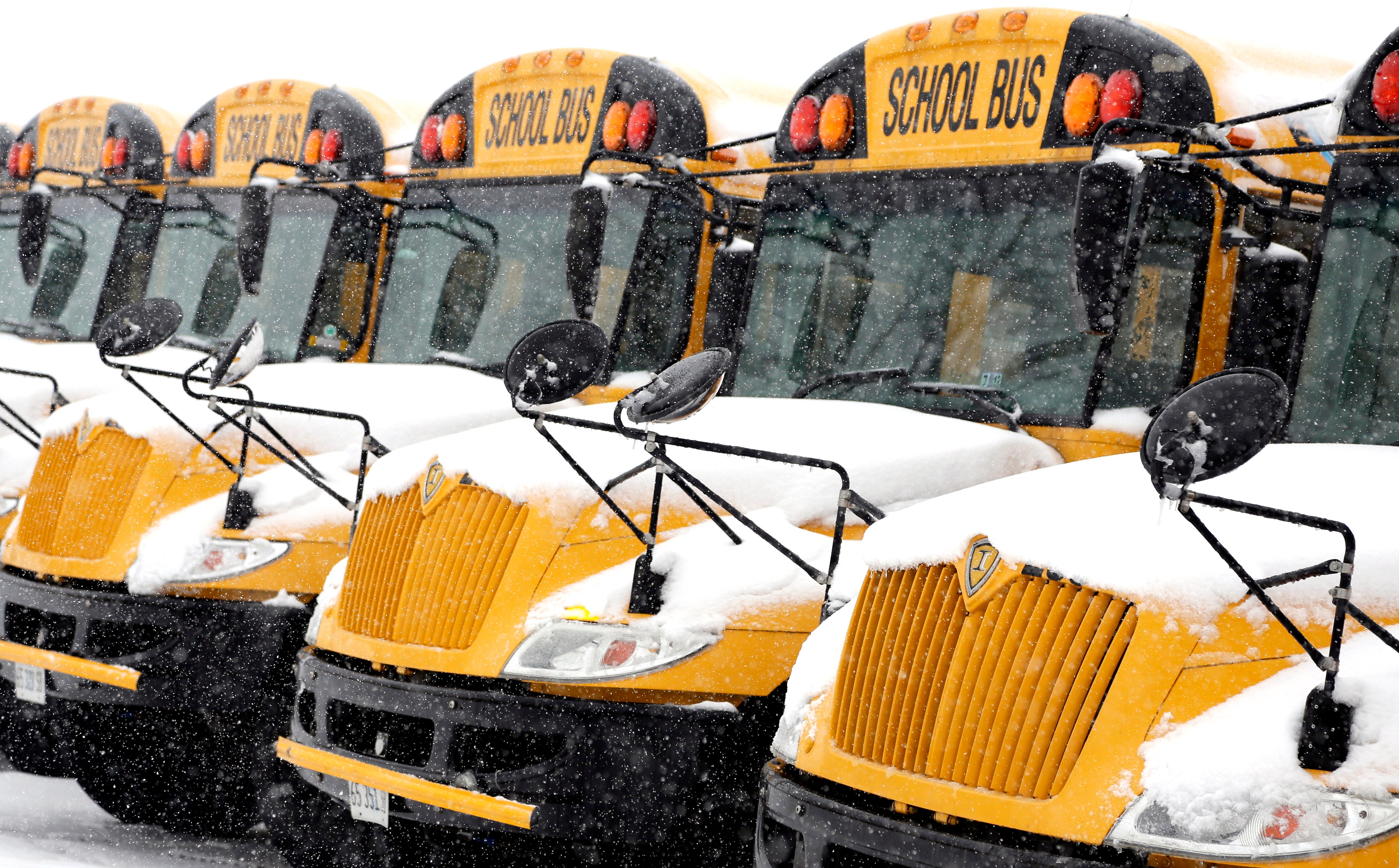 Snow covers the school buses in a parking lot on March 5, 2013. Winter weather has forced more than a dozen school delays, mostly in northern Indiana, on Tuesday, Jan. 9, 2024. (AP Photo/Nam Y. Huh)