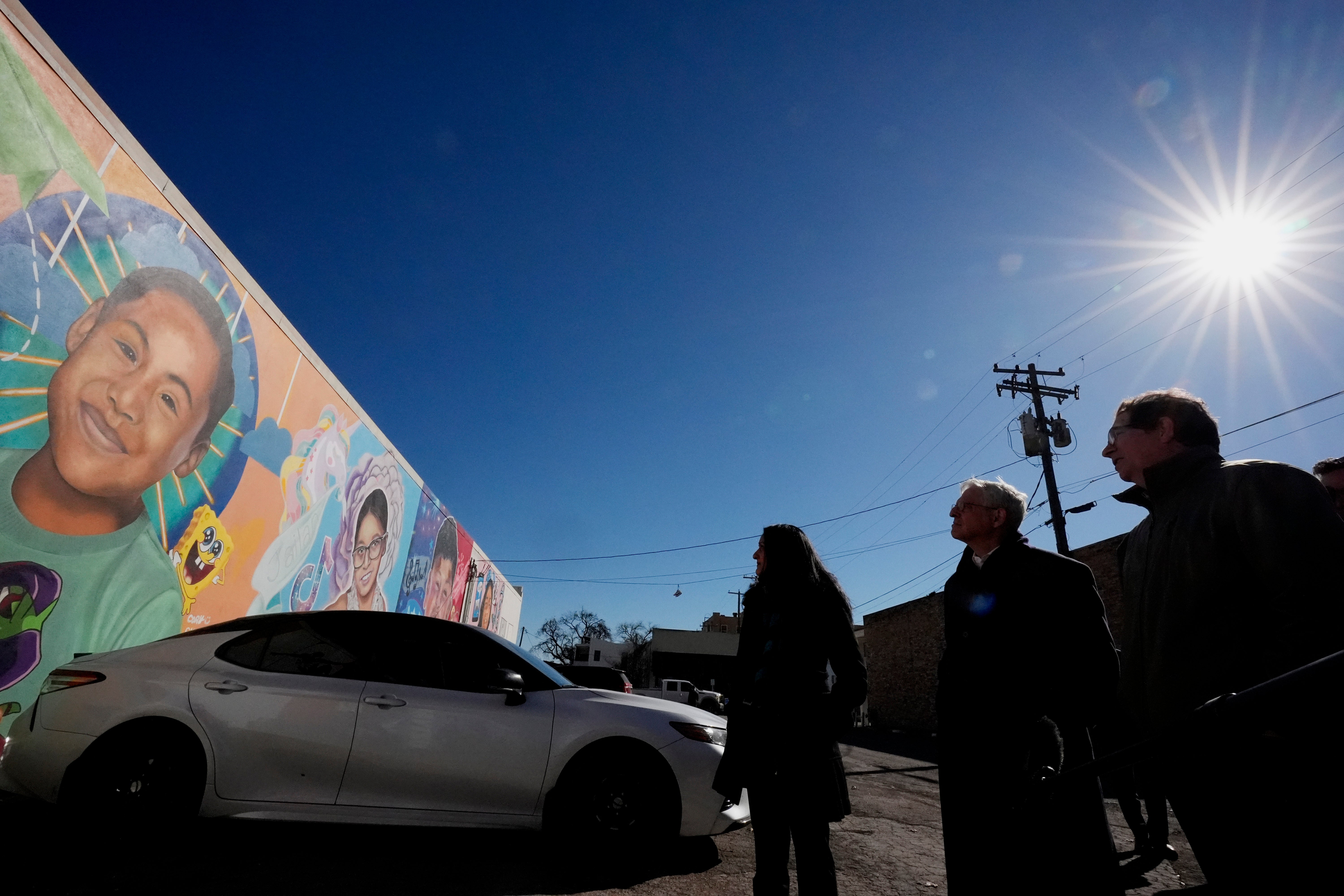 Artist Abel Ortiz, right, gives Attorney General Merrick Garland, center, and Associate Attorney General Vanita Gupta, left, a tour of murals of shooting victims, Wednesday, Jan. 17, 2024, in Uvalde, Texas. The Justice Department is planning this week to release findings of an investigation into the 2022 school shooting.