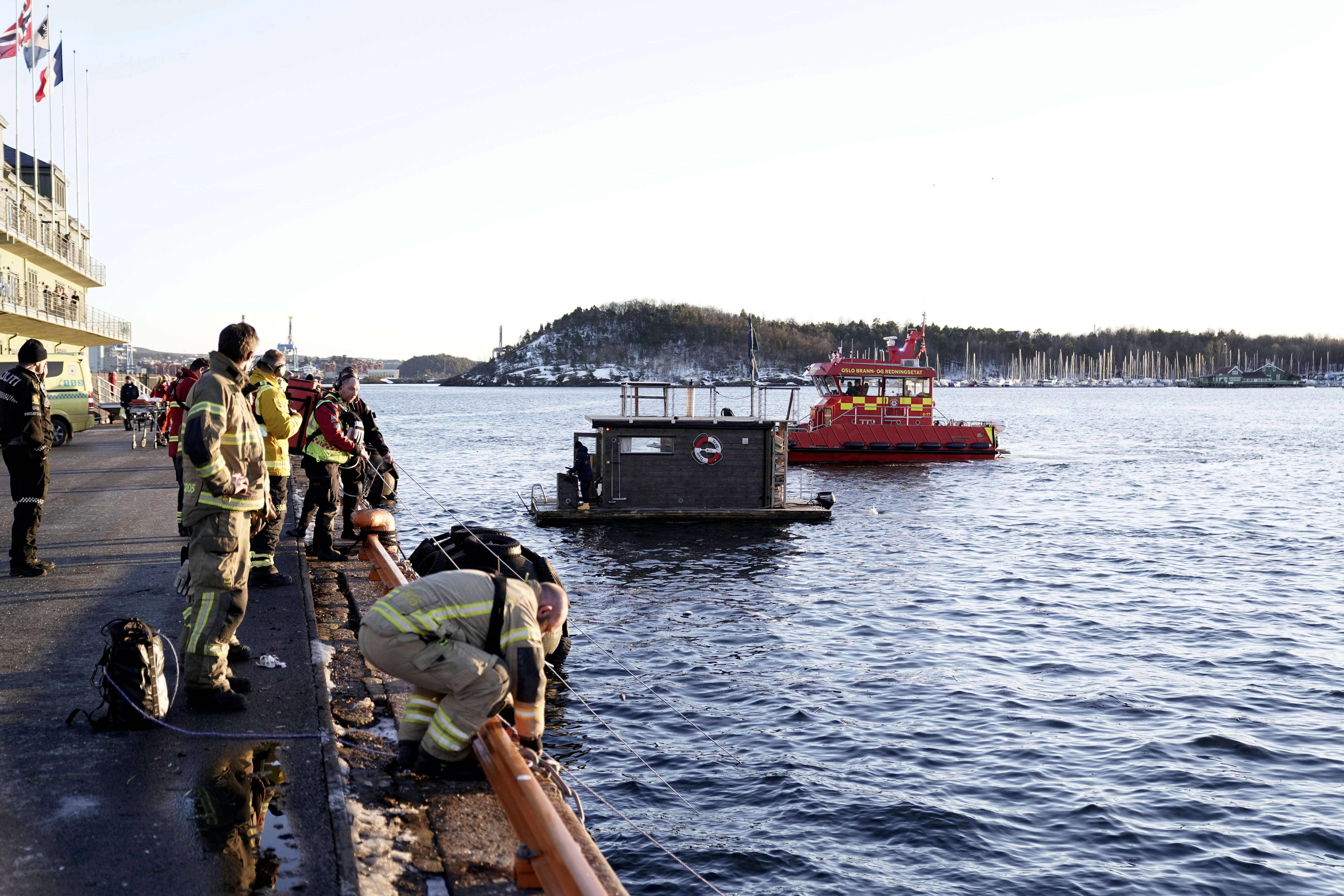 A car is retrieved from the water after driving out into the Oslofjord, in Oslo, Norway, Thursday Feb. 1, 2024. Two people inside the car were rescued by towel-donning patrons of a floating sauna.