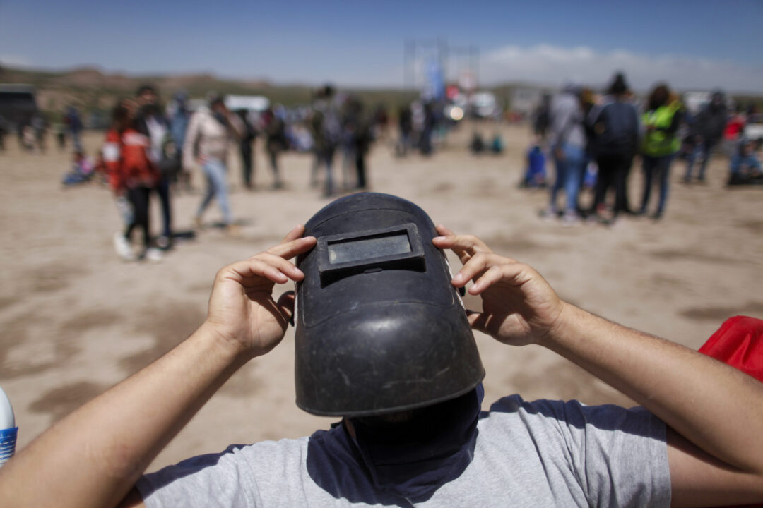Using a welder's mask as protection, a man views a total eclipse in Piedra del Aguila, Argentina, Monday, Dec. 14, 2020. The total solar eclipse was visible from the northern Patagonia region of Argentina and from Araucania in Chile, and as a partial eclipse from the lower two-thirds of South America. (AP Photo/Natacha Pisarenko, File)