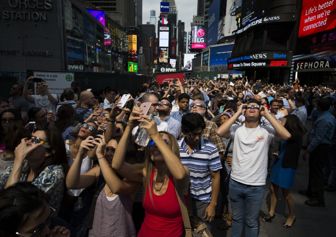 A crowd reacts to the view of a partial solar eclipse as it peaks at over 70% percent coverage on Monday, Aug. 21, 2017, in New York. (AP Photo/Michael Noble Jr.)