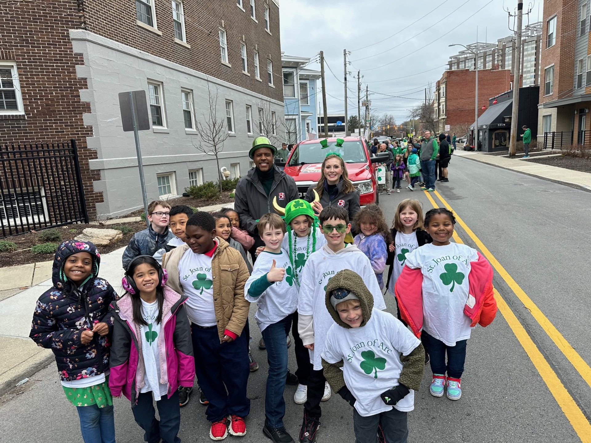 Daybreak's Hanna Mordoh and Jeremy Jenkins enjoy a moment with some adorable youngsters from St, Joan of Arc Catholic School after the annual St. Patrick's Day Parade in downtown Indianapolis on March 15, 2024. (WISH Photo/Hanna Mordoh)