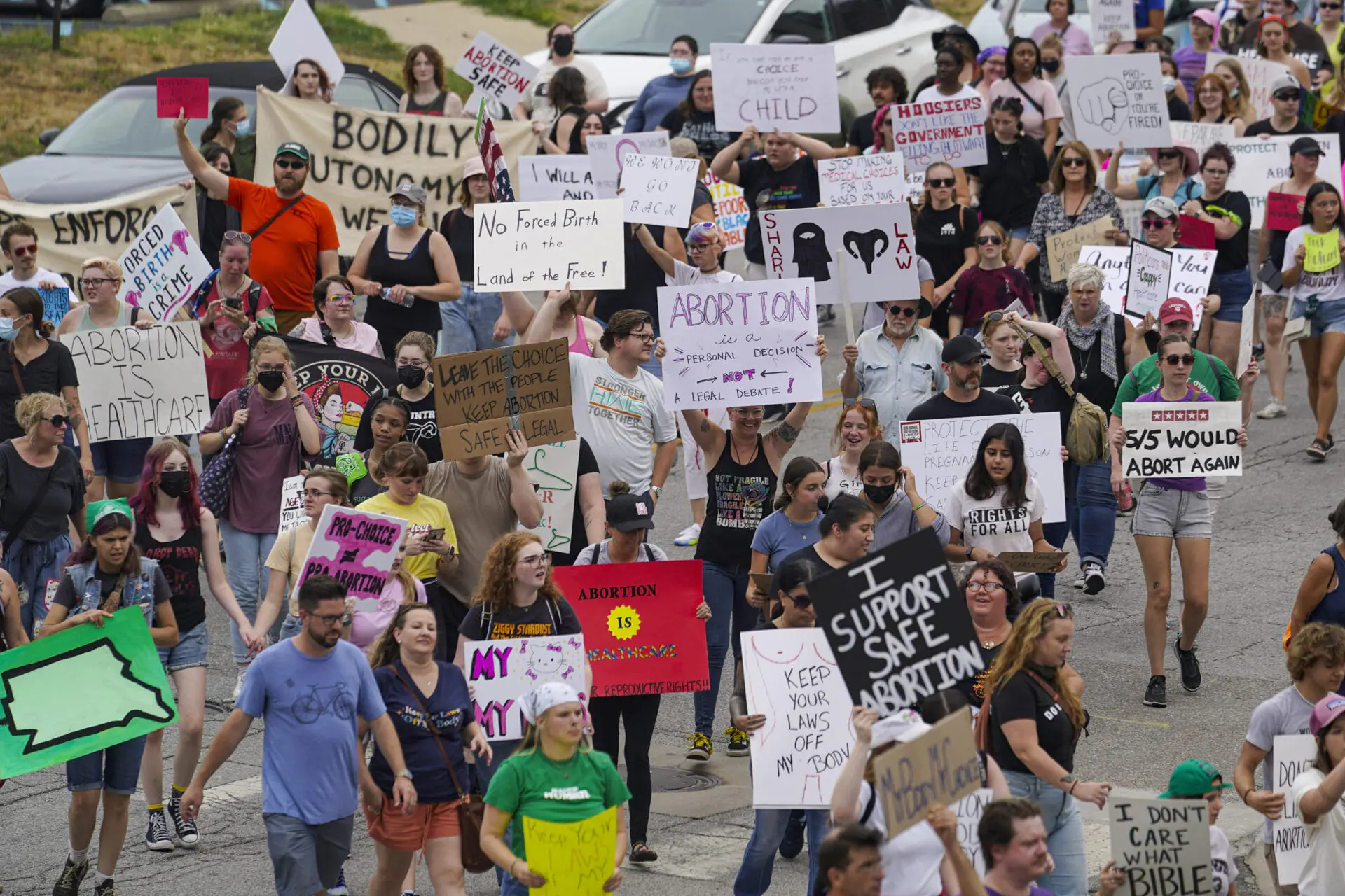 FILE - Abortion-rights protestors march between the Indiana Statehouse and the Indiana State Library where Vice President Kamala Harris was meeting with Indiana legislators to discuss reproductive rights, July 25, 2022, in Indianapolis. After a near-total ban on abortions went into effect in August 2023, some Indiana Republicans want access to reports detailing each abortion still performed in the state.