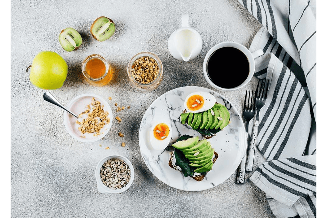 A flat lay photograph of a healthy breakfast concept including eggs, avocado and cup of coffee. Try adding these 10 healthiest snacks for loss into your daily food plan. (Photo by AnikonaAnn/Shutterstock via Stacker)