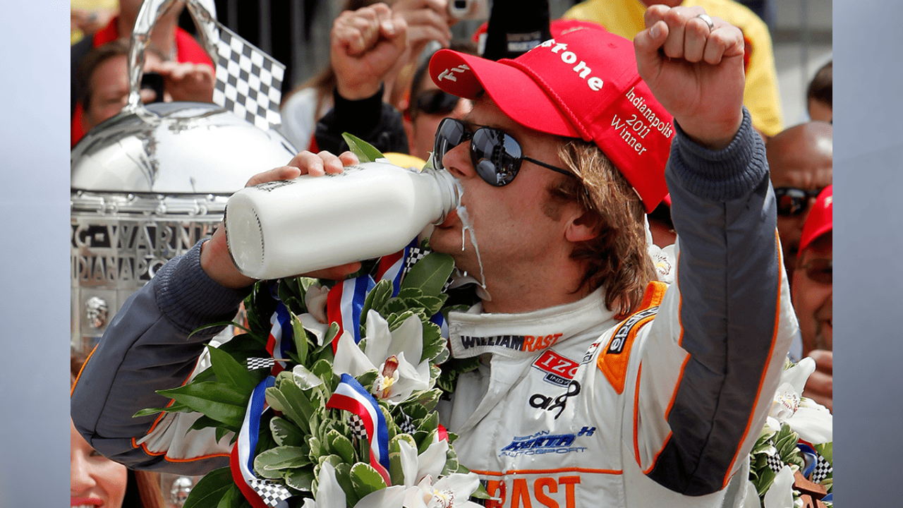 Dan Wheldon, of England, drinks milk in victory lane at Indianapolis Motor Speedway after winning the 2011 Indianapolis. (Photo by Jonathan Ferrey / Getty Images via Stacker)