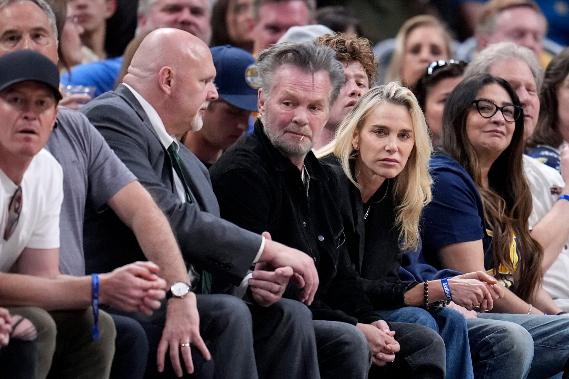 John Mellencamp, center, watches during the second half of Game 4 between the Indiana Pacers and the New York Knicks in an NBA basketball second-round playoff series, Sunday, May 12, 2024, in Indianapolis. (AP Photo/Michael Conroy)