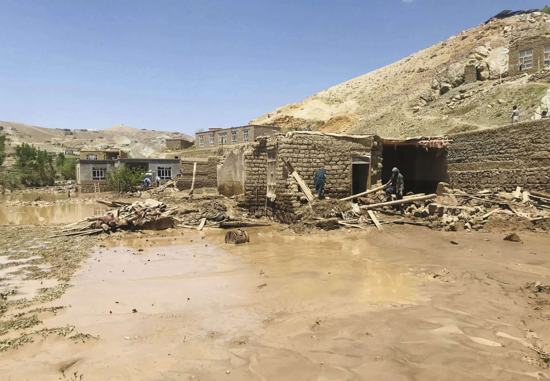 Afghan men collects their belongings from their damaged home after heavy flooding in Ghor province in western Afghanistan Saturday, May 18, 2024. Flash floods from heavy seasonal rains in Ghor province in western Afghanistan killed dozens of people and dozens remain missing, a Taliban official said on Saturday, adding the death toll was based on preliminary reports and might rise.