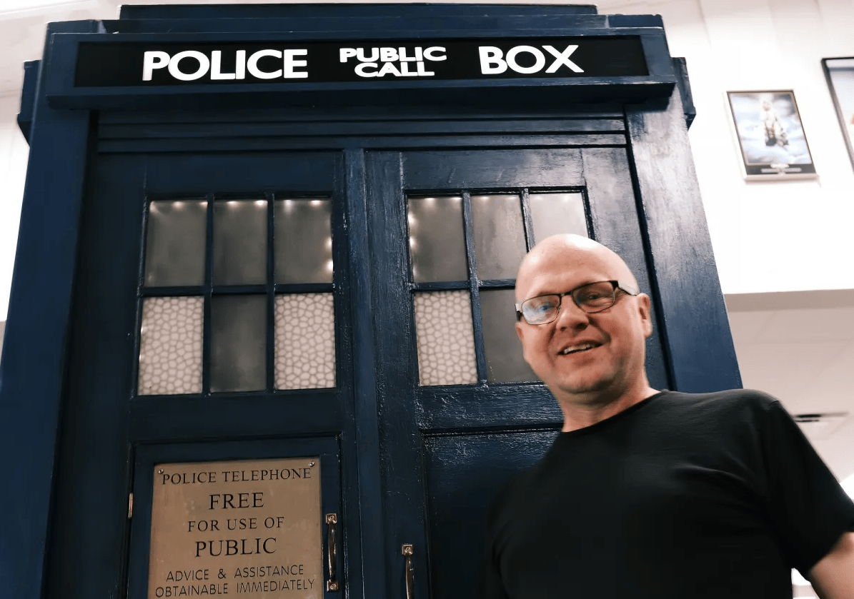 Keith Bradbury, owner of Who North America, poses in front of a life-sized TARDIS on May 14, 2024. Bradbury has been a Doctor Who fan since it first aired in the U.S. in the early 1980s.