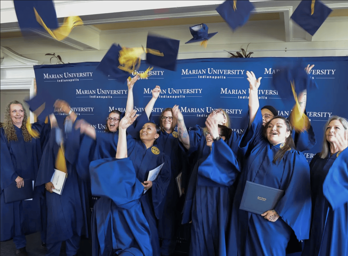 Graduates throw their caps following a commencement ceremony at the Indiana Women’s Prison on May 23, 2024.