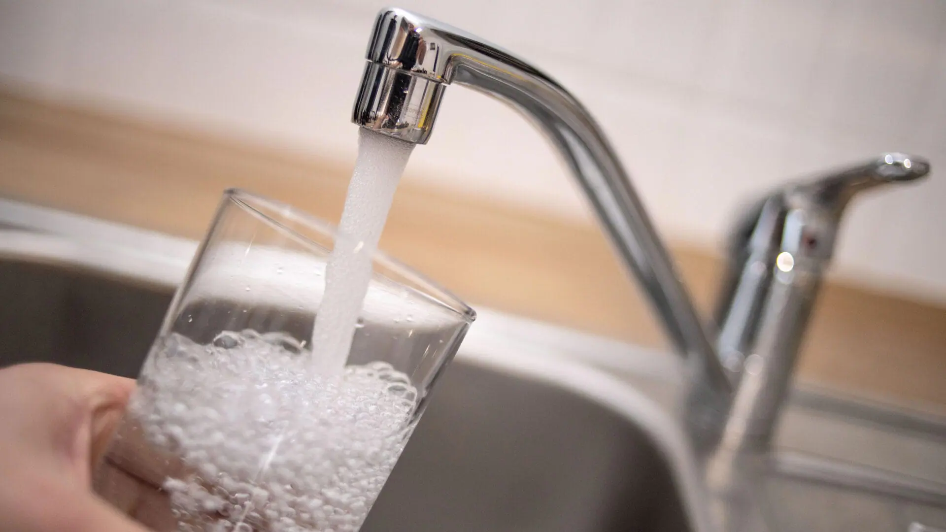 Water coming from a kitchen faucet fills up a glass. (Marius Becker/picture alliance via Getty Images)