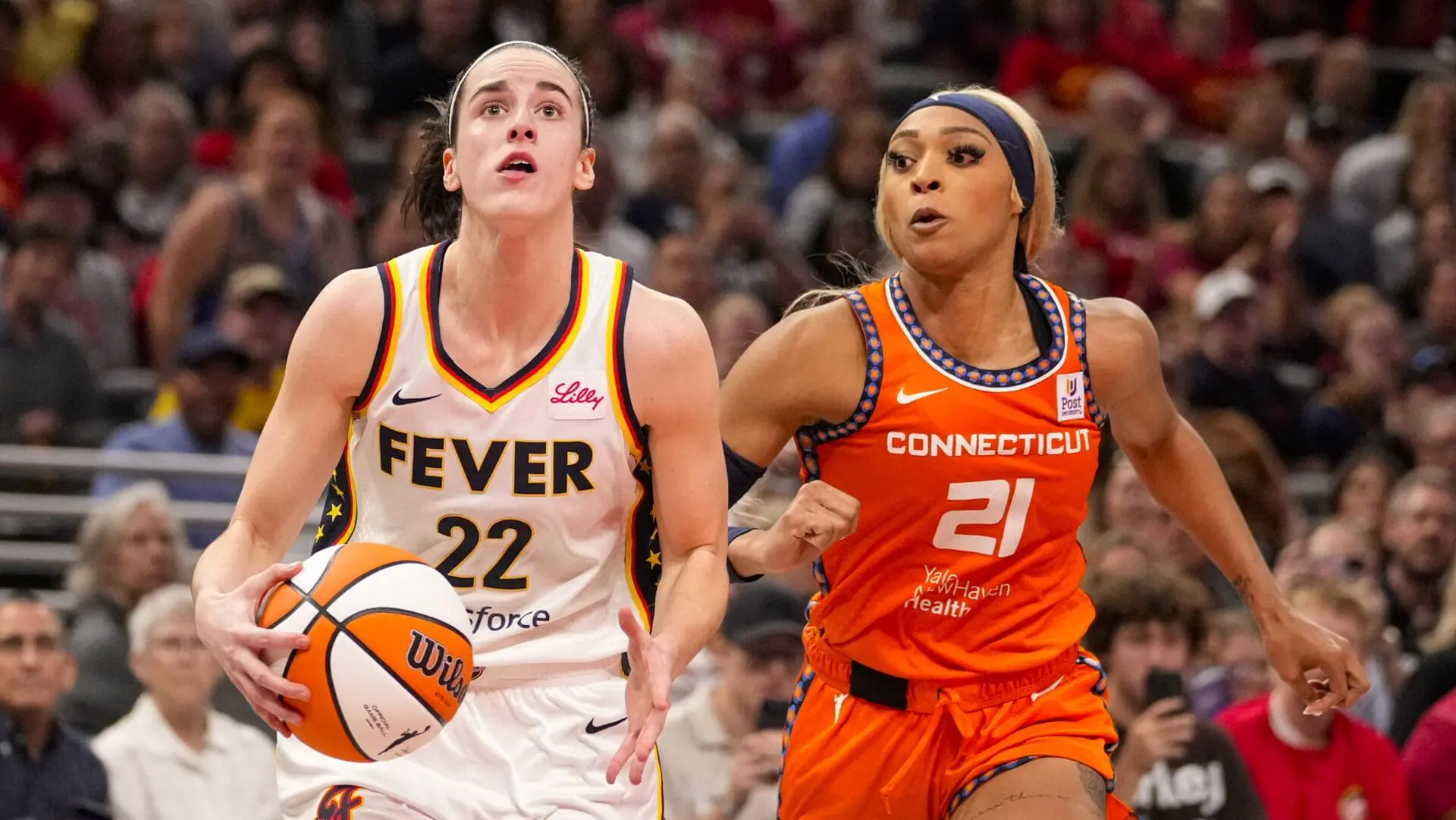 Indiana Fever guard Caitlin Clark (22) shoots in front of Connecticut Sun guard DiJonai Carrington (21) in the second half of a WNBA basketball game in Indianapolis, Monday, May 20, 2024. (AP Photo/Michael Conroy)