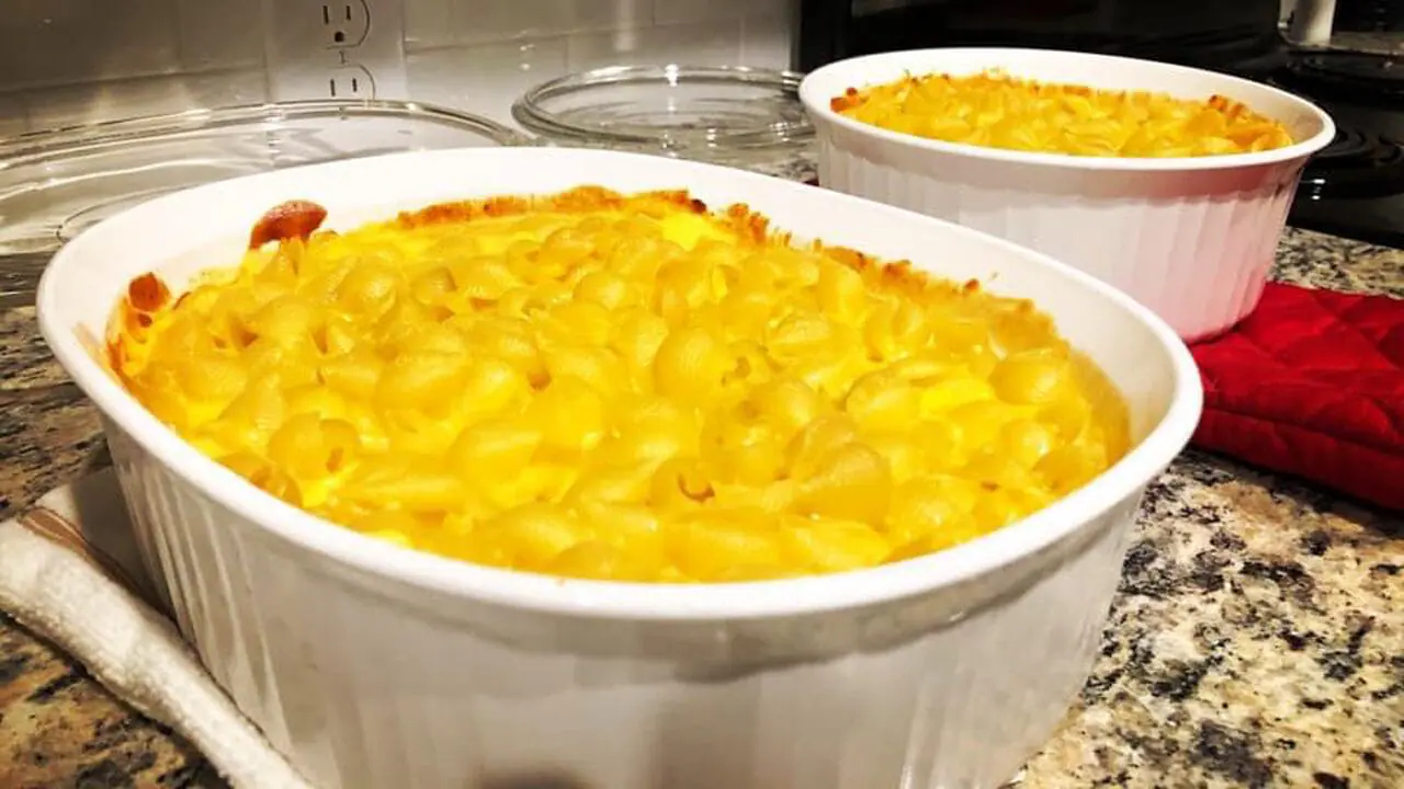 homemade mac n cheese recipe portioned in two ceramic baking dishes on a counter