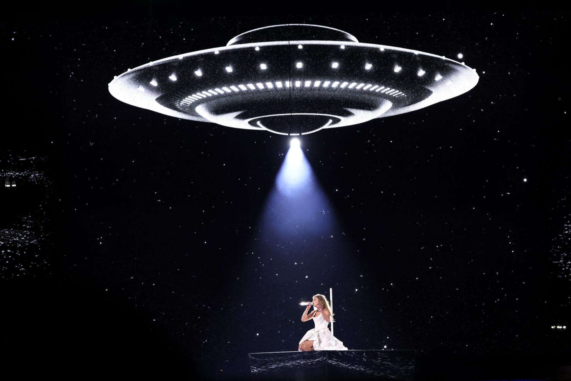 Taylor Swift, shown in a spotlight shining down from a UFO, performs at Groupama Stadium on June 02, 2024 in Lyon, France. (Photo by John Shearer/TAS24/Getty Images for TAS Rights Management)
