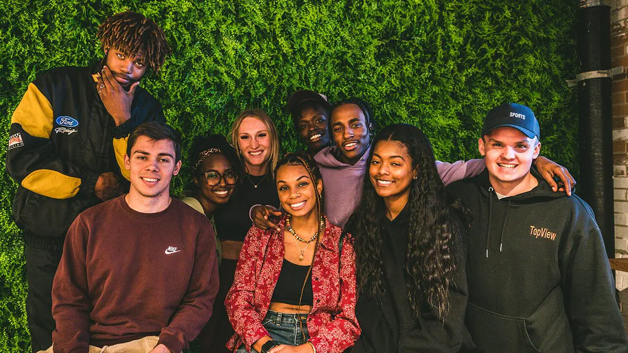 TopView team members pose in front of a leafy wall