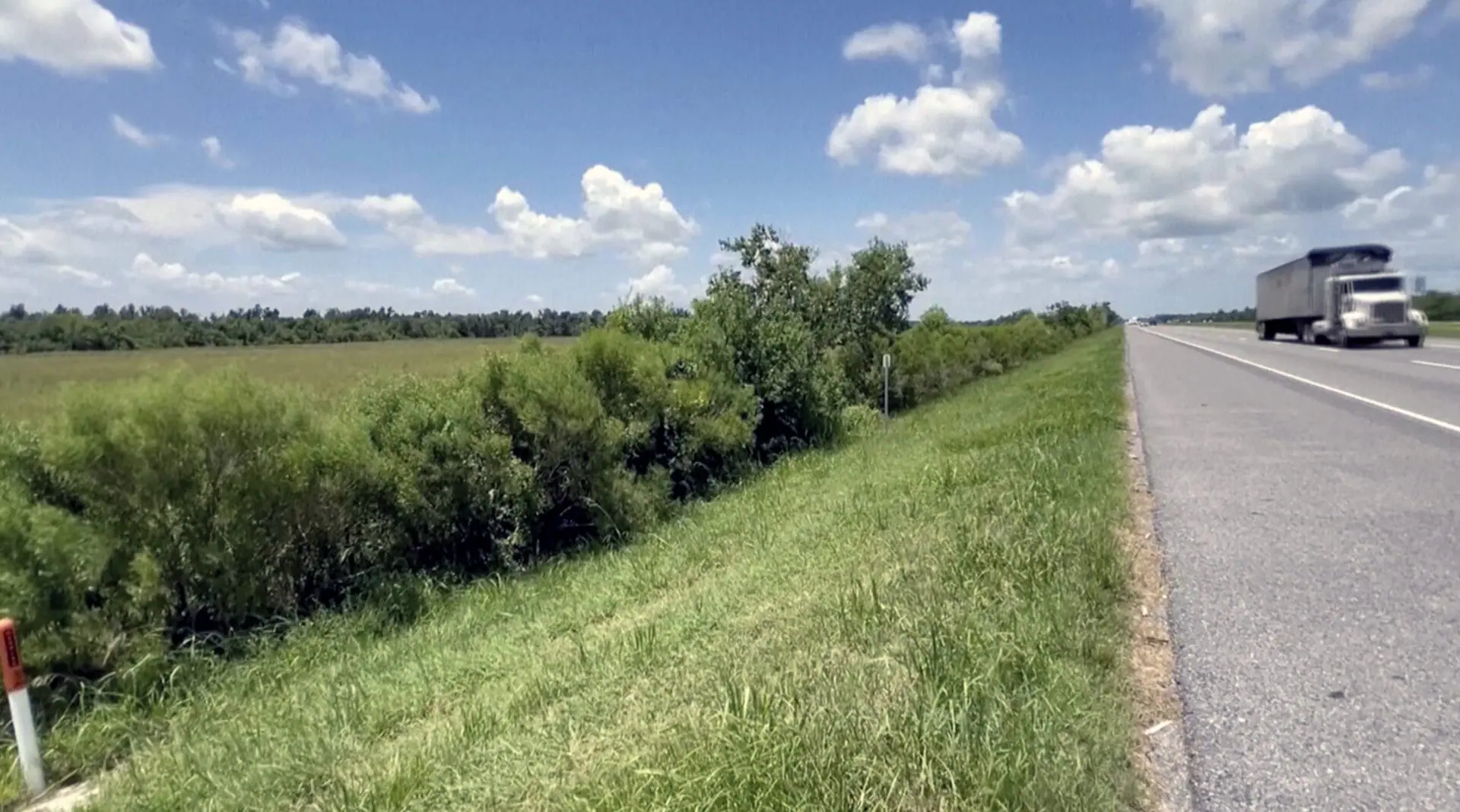 This image made from video provided by KPLC shows a truck passing along the highway where a 1-year-old child was found on Tuesday, July 9, 2024. Speaking at a press conference, Calcasieu Parish Sheriff Gary “Stitch” Guillory said the “miracle baby” survived two days of sometimes stormy weather before a truck driver spotted him crawling along the road the day after his 4-year-old brother was found dead and his mother was arrested in Mississippi. (KPLC via AP)