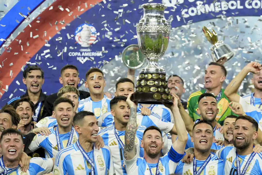 Argentina's Lionel Messi holds the trophy while celebrating with teammates after defeating Colombia in the Copa America final soccer match in Miami Gardens, Fla., Monday, July 15, 2024. (AP Photo/Rebecca Blackwell)