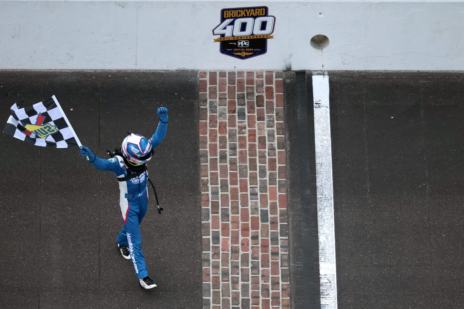 Kyle Larson, driver of the #5 HendrickCars.com Chevrolet, celebrates with the checkered flag after winning the NASCAR Cup Series Brickyard 400 at Indianapolis Motor Speedway on July 21, 2024 in Indianapolis, Indiana. (Photo by James Gilbert/Getty Images)