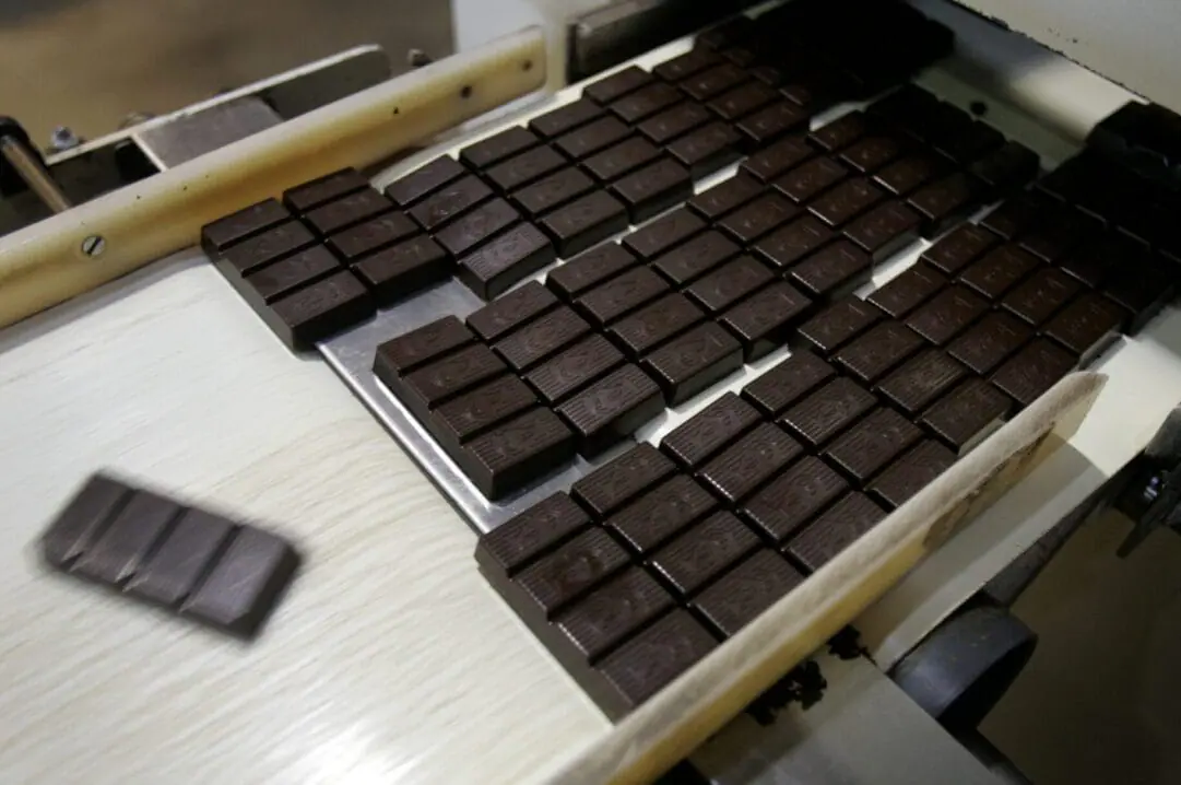 One ounce bars of dark chocolate roll off a conveyor belt at the Scharffen Berger chocolate factory in Berkeley, Calif. on Tuesday, July 3, 2007. Dark chocolate and similar cocoa products are contaminated with lead and cadmium, two neurotoxic metals that are linked to cancer, chronic disease, or reproductive and developmental issues, especially in children, a new study found. (Photo By Paul Chinn/The San Francisco Chronicle via Getty Images)