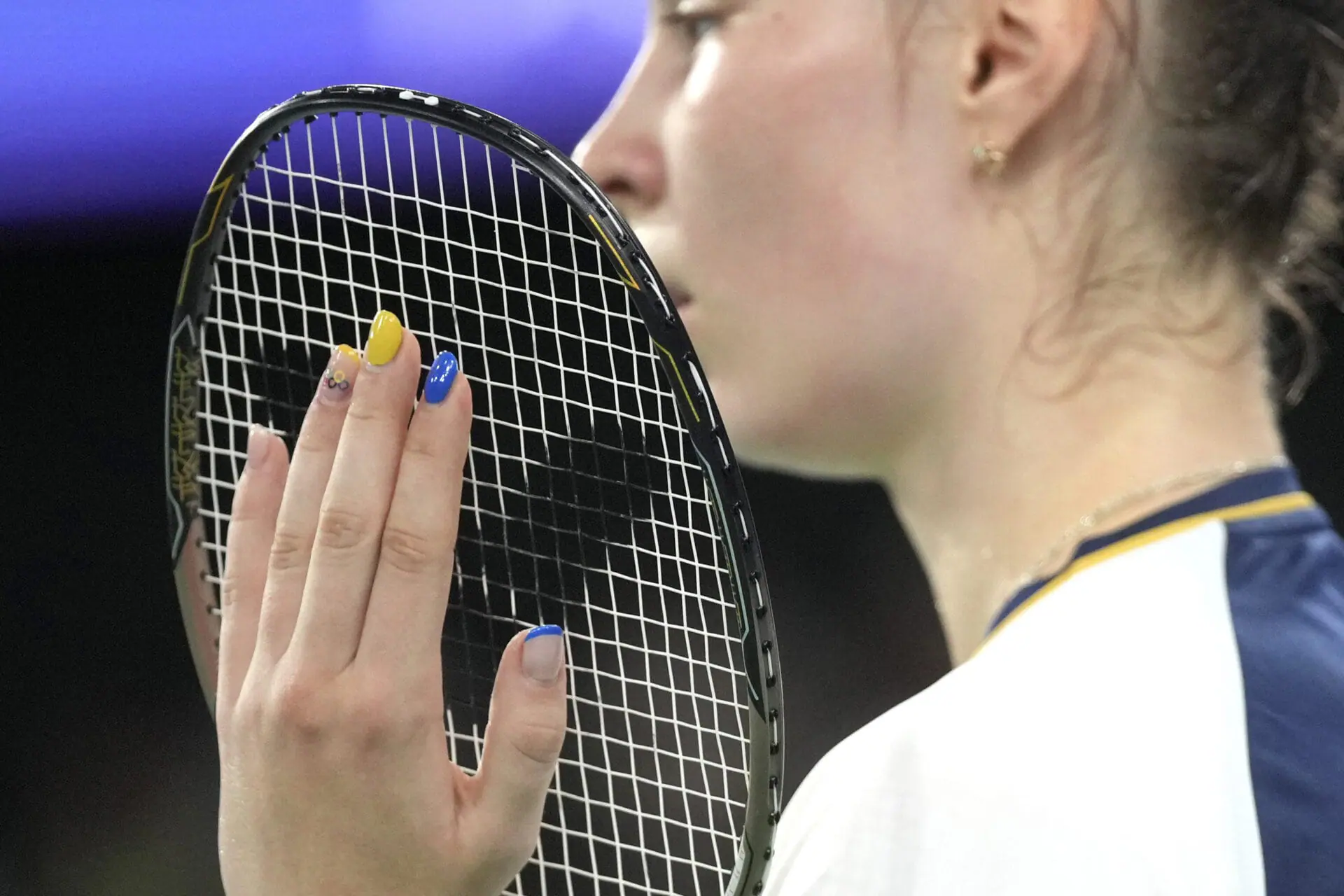 Ukraine's Polia Buhrova has her finger nails painted with the colors of Ukrainian flag and the Olympic rings during her women's singles badminton group stage match against Czechia's Tereza Svabikova at Porte de la Chapelle Arena during the 2024 Summer Olympics, Tuesday, July 30, 2024, in Paris, France. (AP Photo/Dita Alangkara)