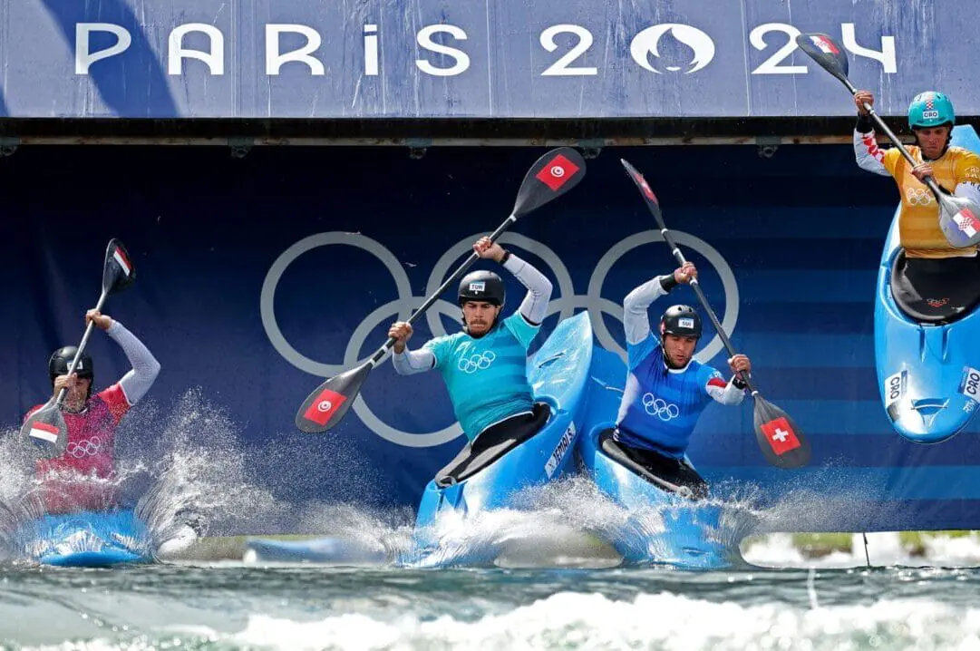 Boris Neveu of Team France (L), Salim Jemai of Team Turkiye, Martin Dougoud of Team Switzerland and Matija Marinic of Team Croatia compete during the Canoe Slalom Men's Kayak Cross Heats on day nine of the Olympic Games Paris 2024 at Vaires-Sur-Marne Nautical Stadium on August 04, 2024 in Paris, France. (Photo by Justin Setterfield/Getty Images)