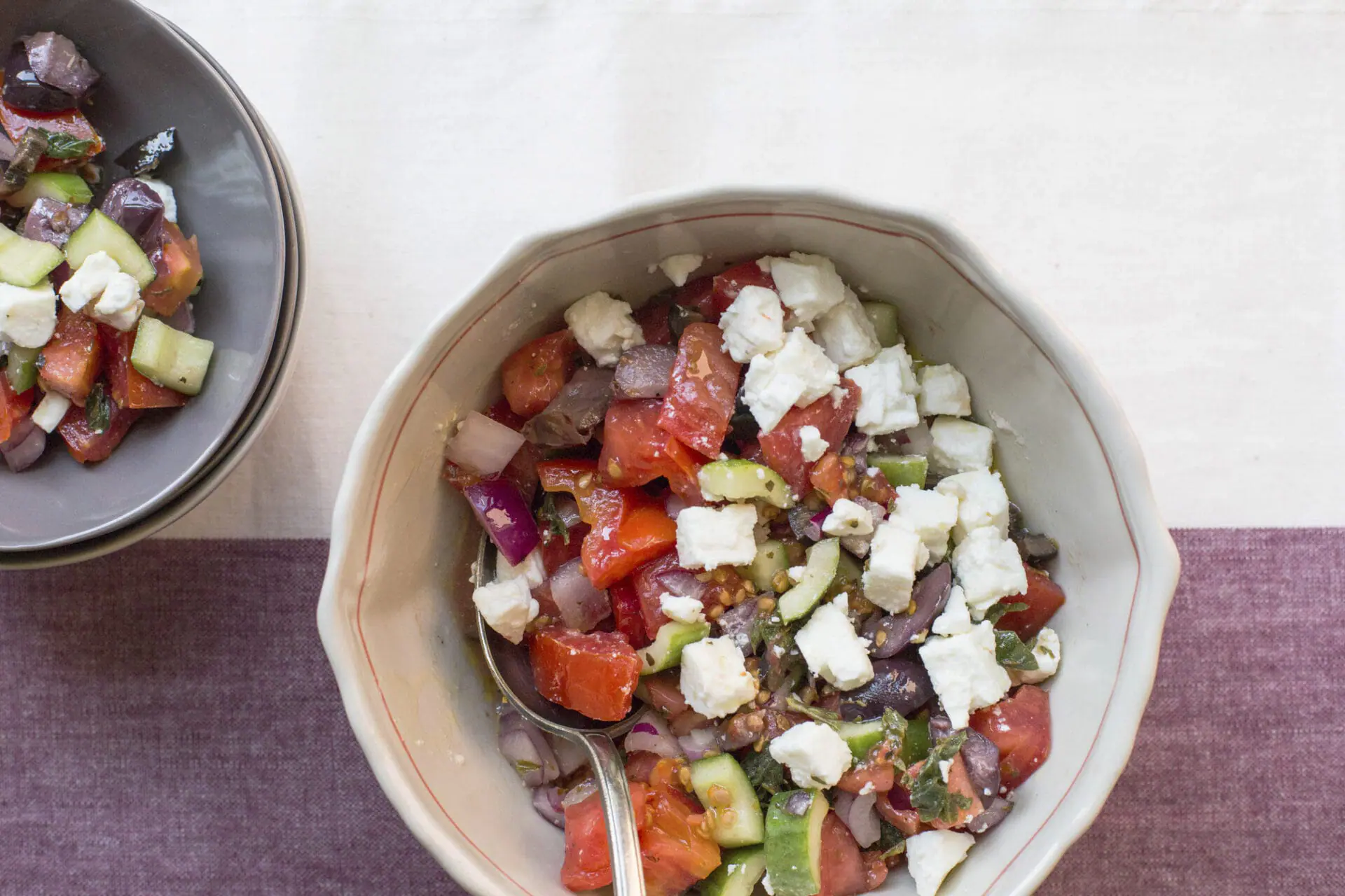 This image shows a traditional Greek salad with fresh cucumbers, tomatoes, feta, onion, and olives. (Katie Workman via AP)