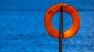 A life preserver hangs from a pole on a jetty on the shore of a lake. Two Indiana man died and a 7-year-old girl was found safe after their fishing boat capsized on an Illinois lake. (Photo by Jens Büttner/picture alliance via Getty Images)