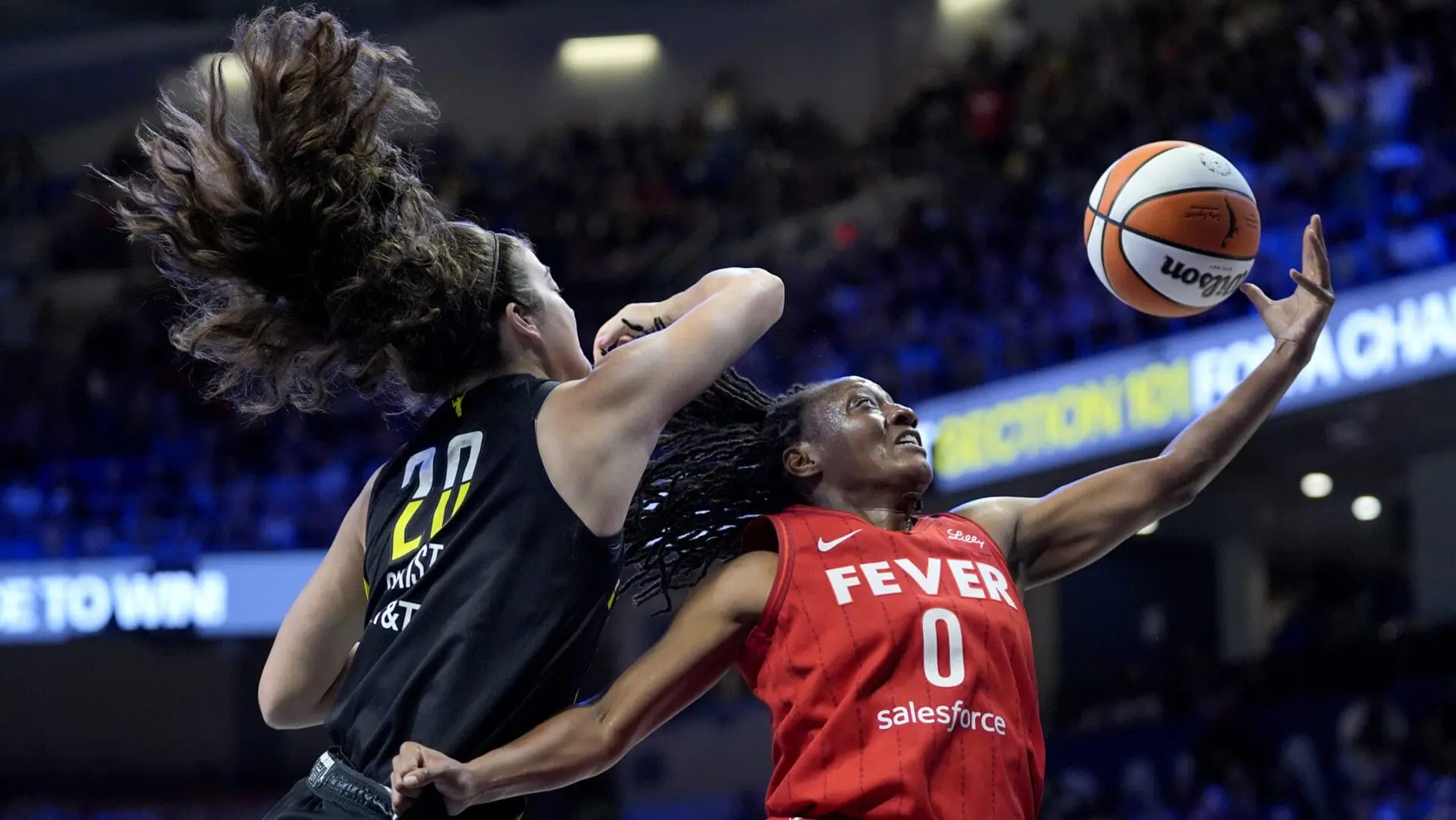 Indiana Fever guard Kelsey Mitchell (0) is blocked on a shot by Dallas Wings' Maddy Siegrist (20) in the first half of a WNBA basketball game Sunday, Sept. 1, 2024, in Arlington, Texas. (AP Photo/Tony Gutierrez)