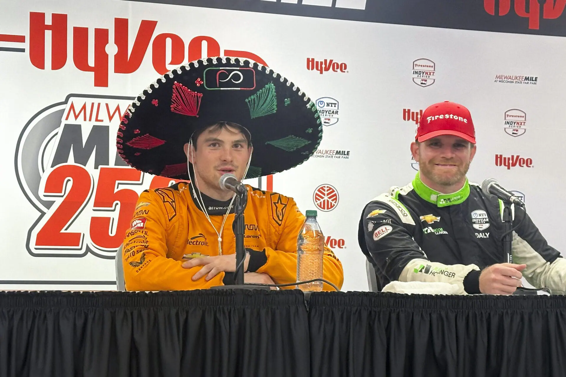 Pato O’Ward, of Mexico, left, wears a sombrero at the post-race news conference after winning the IndyCar auto race at the Milwaukee Mile in West Allis, Wis., Saturday, Aug. 31, 2024. (AP Photo/Jenna Fryer)