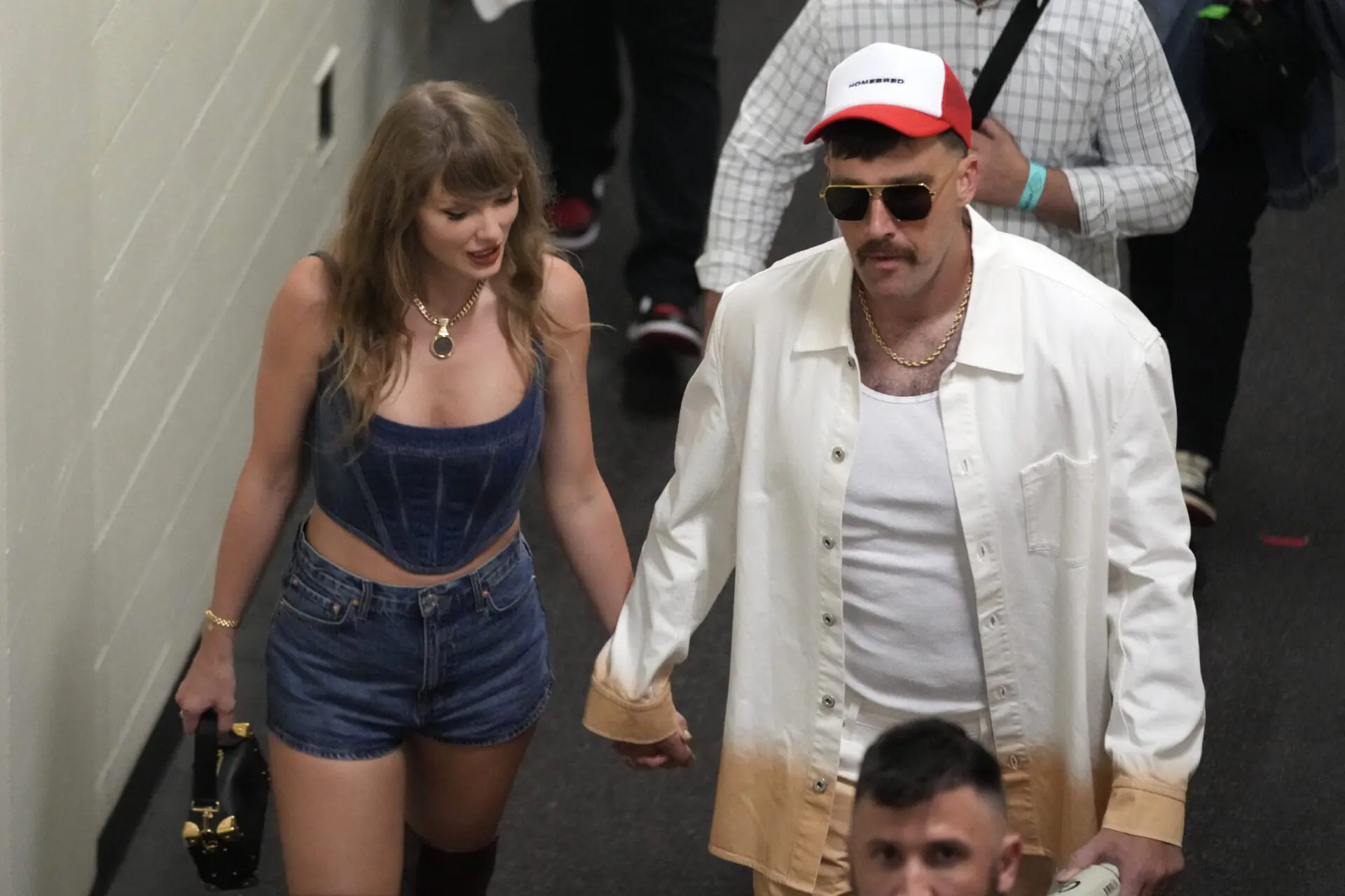 Kansas City Chiefs tight end Travis Kelce, right, and Taylor Swift hold hands following an NFL football game between the Chiefs and the Baltimore Ravens Thursday, Sept. 5, 2024, in Kansas City, Mo. The Chiefs won 27-20. (AP Photo/Ed Zurga)