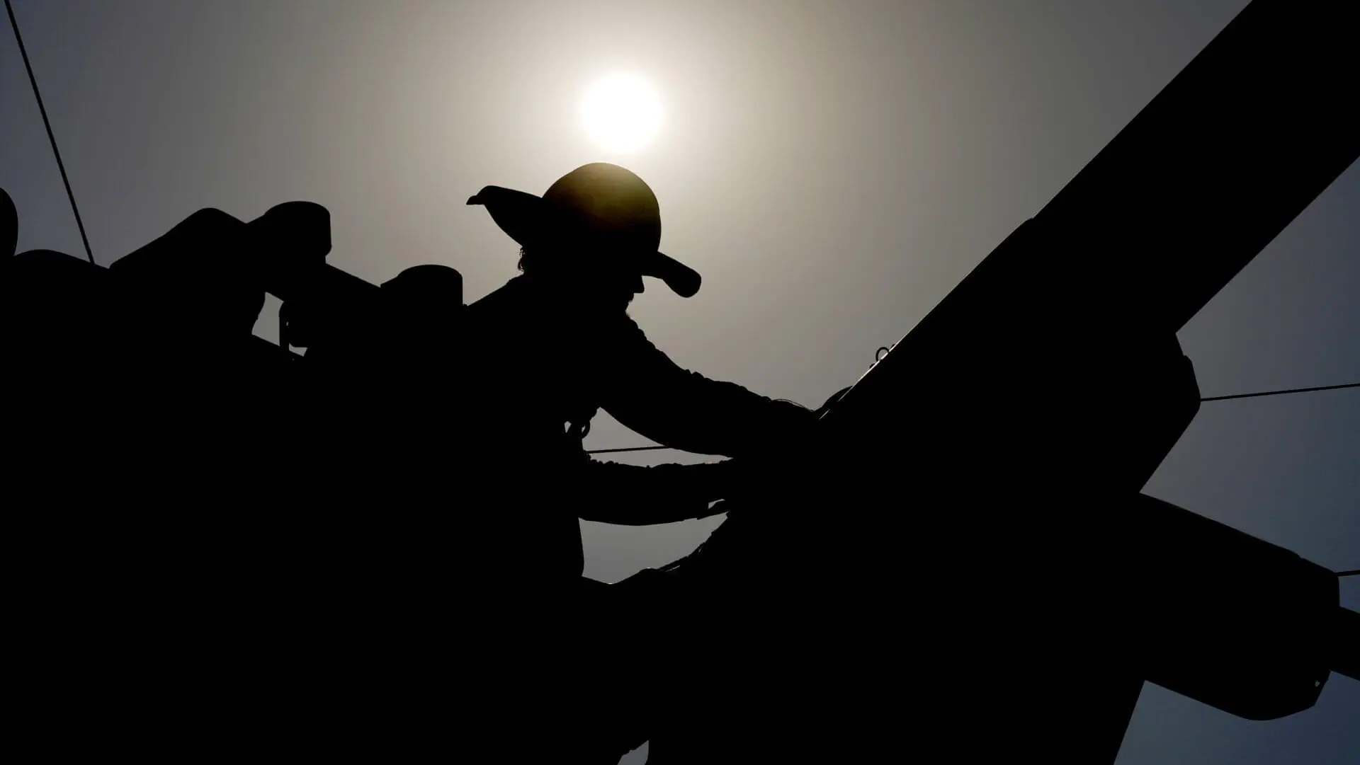 A linesman works on power lines under the morning sun, July 12, 2024. Five rural infrastructure projects in Indiana have received funding from the US Department of Agriculture. (AP Photo/Matt York, File)