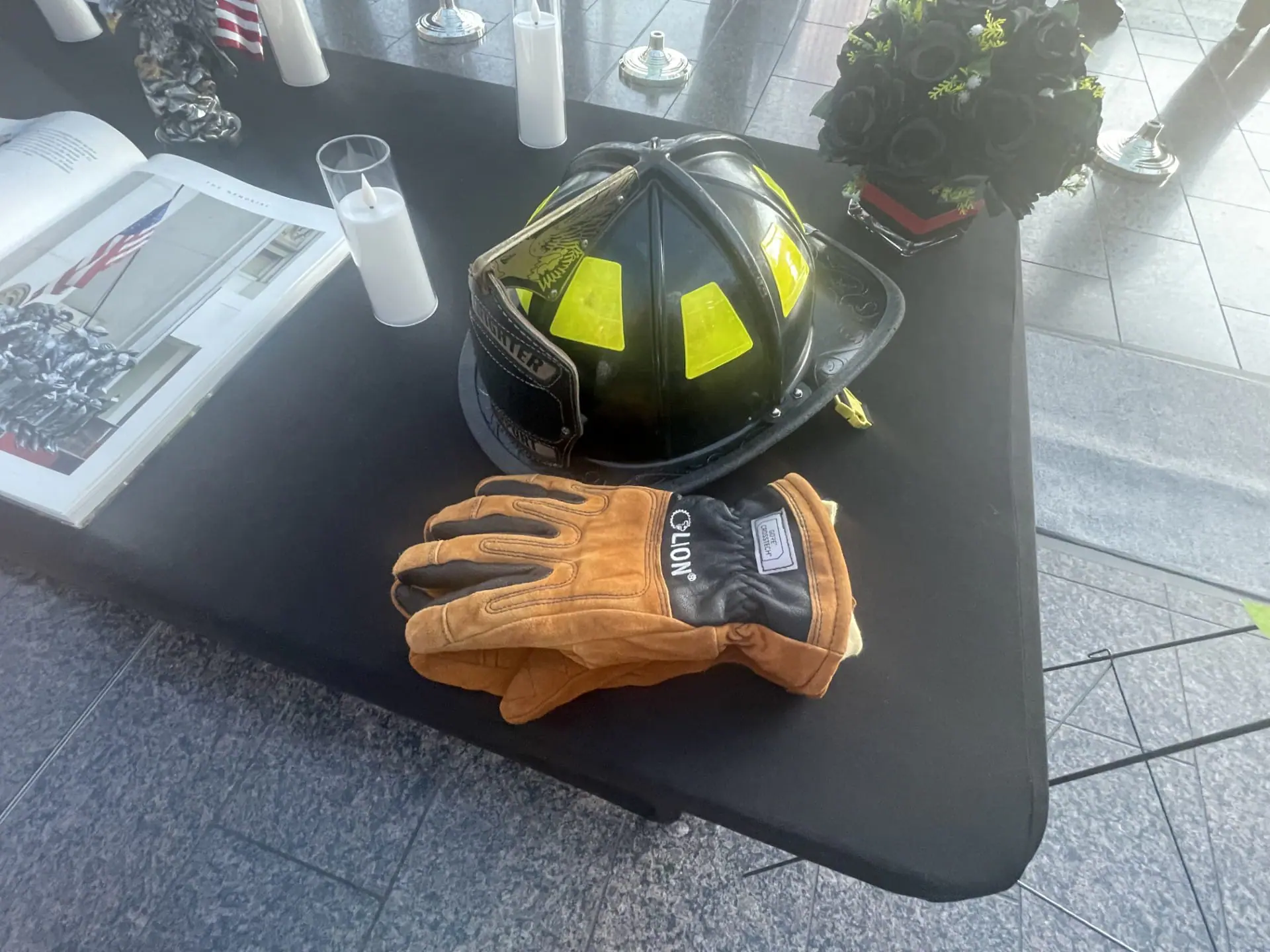 A firefighter's helmet and glove rest on a table among various other items collected to honor first responders and Indiana Task Force 1 on Sept. 11, 2024. (WISH Photo)