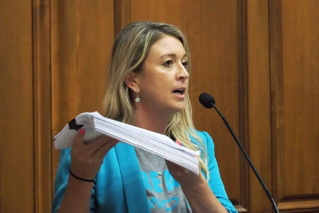 Sexual assault survivor Carissa Siekmann holds up a petition she says contains hundreds of signatures in support of legislation ending the statute of limitations for sexual assault cases. She spoke during an interim committee meeting on Tuesday, Sept. 10, 2024. (Photo by Leslie Bonilla Muñiz/Indiana Capital Chronicle)