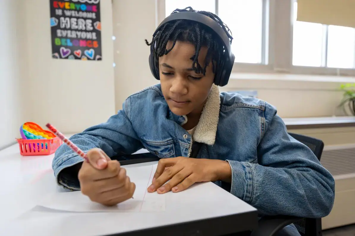 Corey Bass works on a project in the writing club. A writing club gathers for their weekly meeting Friday, March 1, 2024, at Crispus Attucks High School in Indianapolis. (Provided Photo/Doug McSchooler for Mirror Indy)