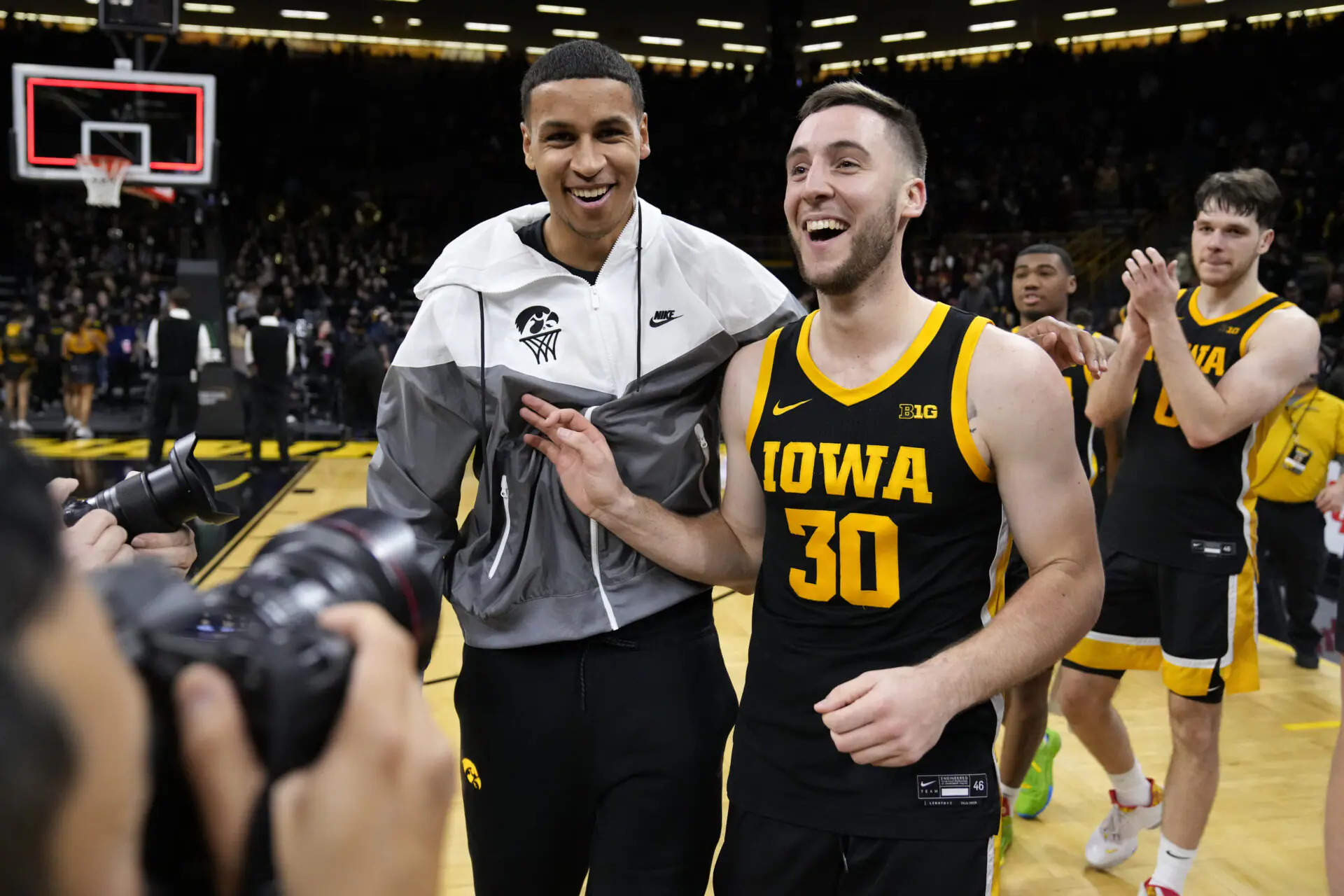 Iowa guard Connor McCaffery (30) walks off the court with teammate Kris Murray after an NCAA college basketball game against Iowa State, Thursday, Dec. 8, 2022, in Iowa City, Iowa. Iowa won 75-56. (AP Photo/Charlie Neibergall)