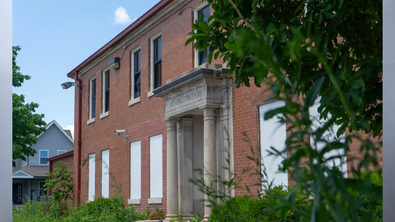 The administration building of the former Indiana Women’s Prison is seen through weeds June 27, 2024, in Indianapolis. The prison has been unoccupied since 2017. (Photo by Alayna Wilkening/Mirror Indy)