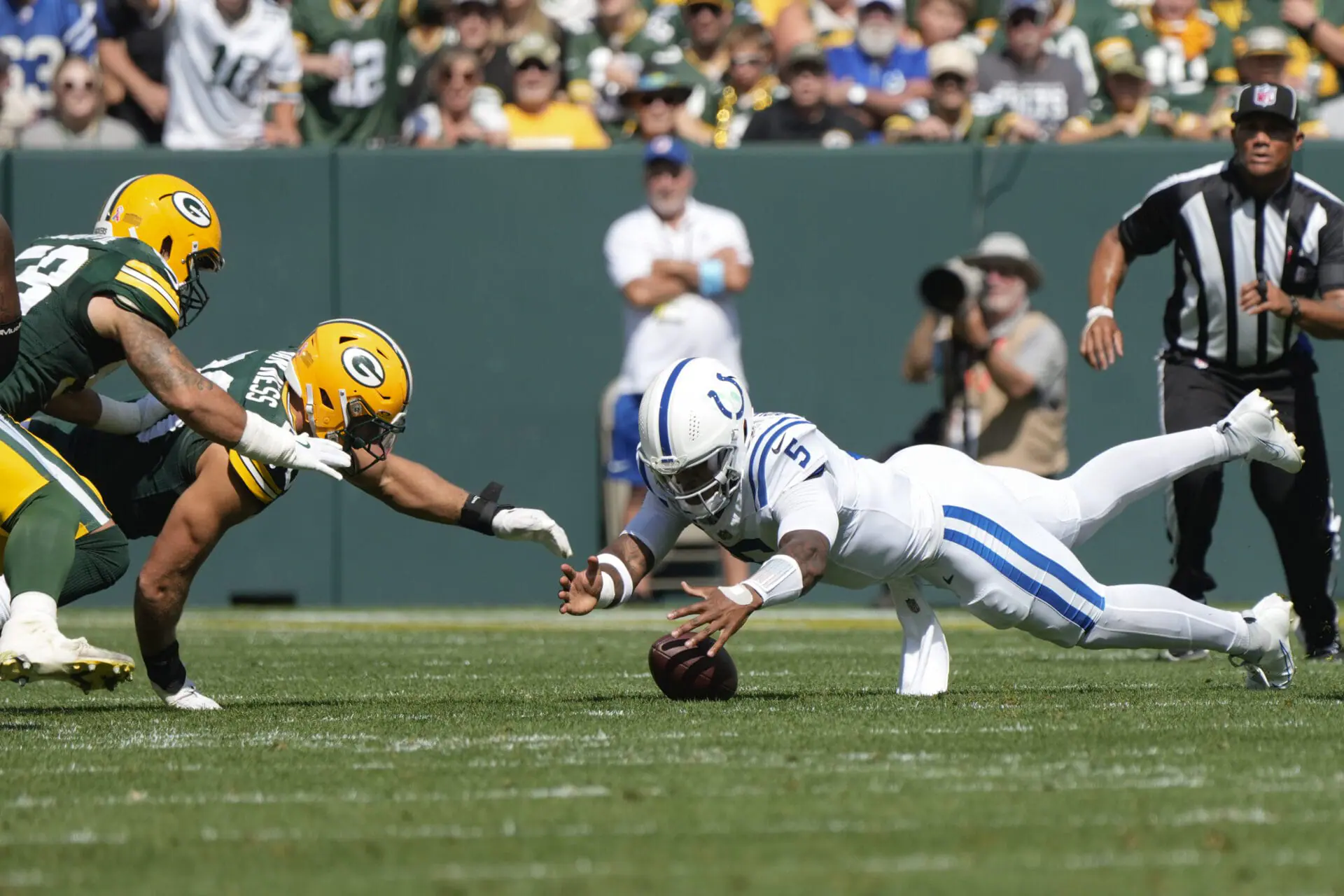 Indianapolis Colts quarterback Anthony Richardson (5) battles Green Bay Packers' Lukas Van Ness (90) and Isaiah McDuffie (58), left, as he recovers his own fumble during the first half of an NFL football game Sunday, Sept. 15, 2024, in Green Bay, Wis. (AP Photo/Morry Gash)