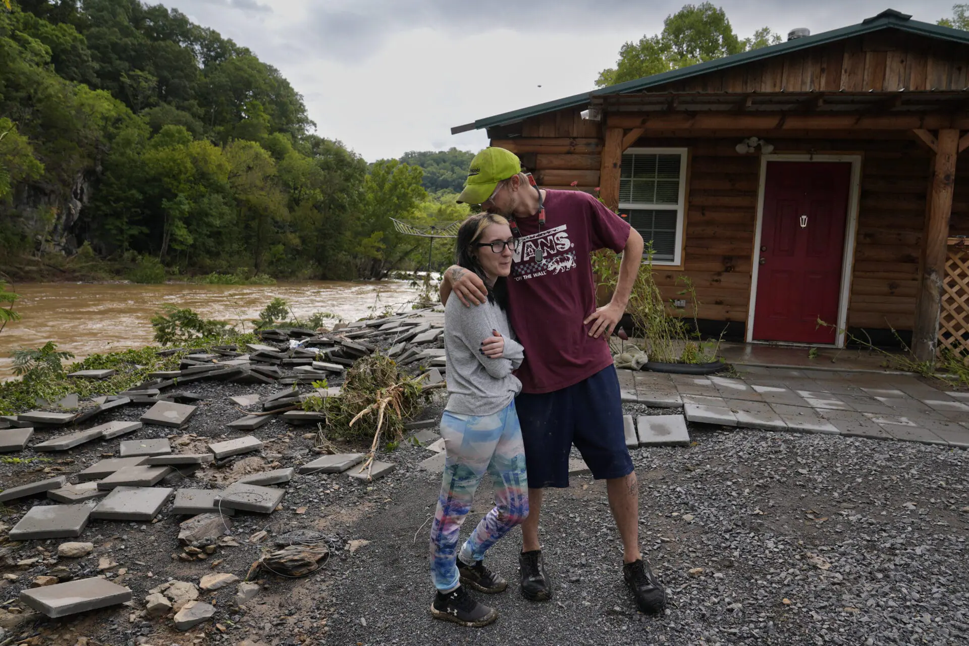 Jonah Wark, right, kisses his wife Sara Martin outside their flood-damaged home on the Pigeon River in the aftermath of Hurricane Helene, Saturday, Sept. 28, 2024, in Newport, Tenn. (AP Photo/George Walker IV)