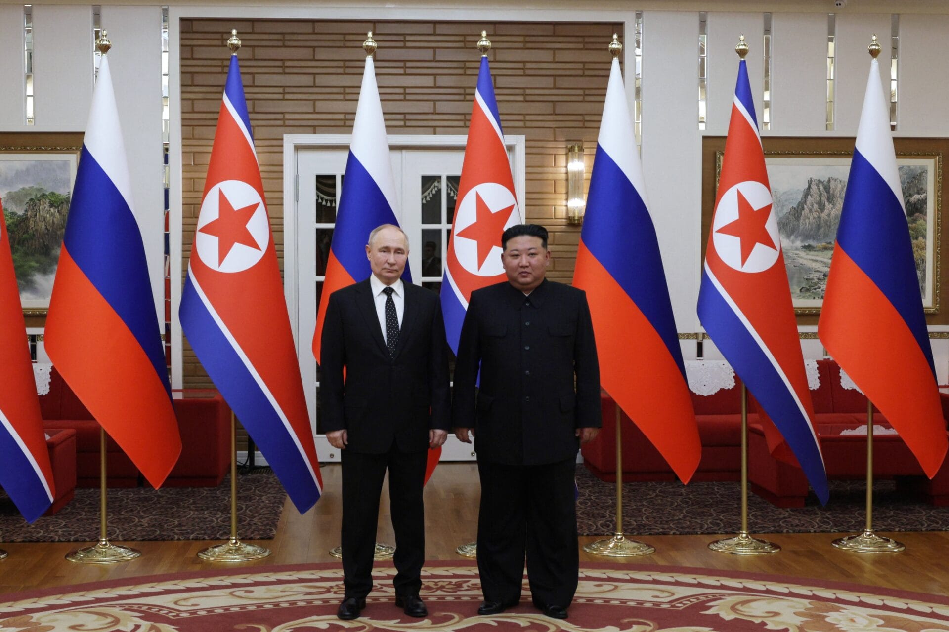 TOPSHOT - In this pool photograph distributed by the Russian state agency Sputnik, North Korea's leader Kim Jong Un (R) and and Russian President Vladimir Putin pose after a welcoming ceremony at Kim Il Sung Square in Pyongyang on June 19, 2024. Russian President Vladimir Putin landed in North Korea early on June 19, the Kremlin said, kicking off a visit set to boost defence ties between the two nuclear-armed countries as Moscow pursues its war in Ukraine. (Photo by Gavriil GRIGOROV / POOL / AFP) / -- Editor's note : this image is distributed by the Russian state owned agency Sputnik -- (Photo by GAVRIIL GRIGOROV/POOL/AFP via Getty Images)