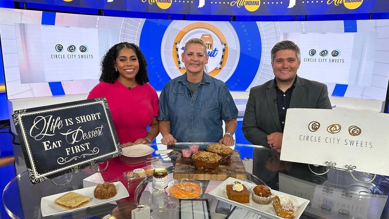 Circle City Sweets owner Cindy Hawkins in front of a display of sweets with Felicia and Cody